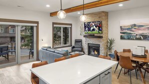 Una cocina moderna con una isla grande, una chimenea y un comedor con una mesa redonda y sillas.
