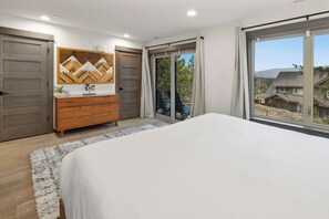 A bedroom with a large bed, wooden dresser, and a sliding glass door leading to a balcony. - 3BR Chef Kitch GameRM BBQ Steps to Hike Bike Golf Spa (Cle Elum)