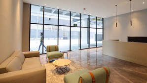 A spacious lobby with a large glass wall, a reception desk, and comfortable seating.