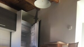 A kitchen with a dishwasher, a built-in oven, and a bar area with two stools. - 5 minutes to the center, 5 minutes to the forest, a cozy little apartment (Selb)