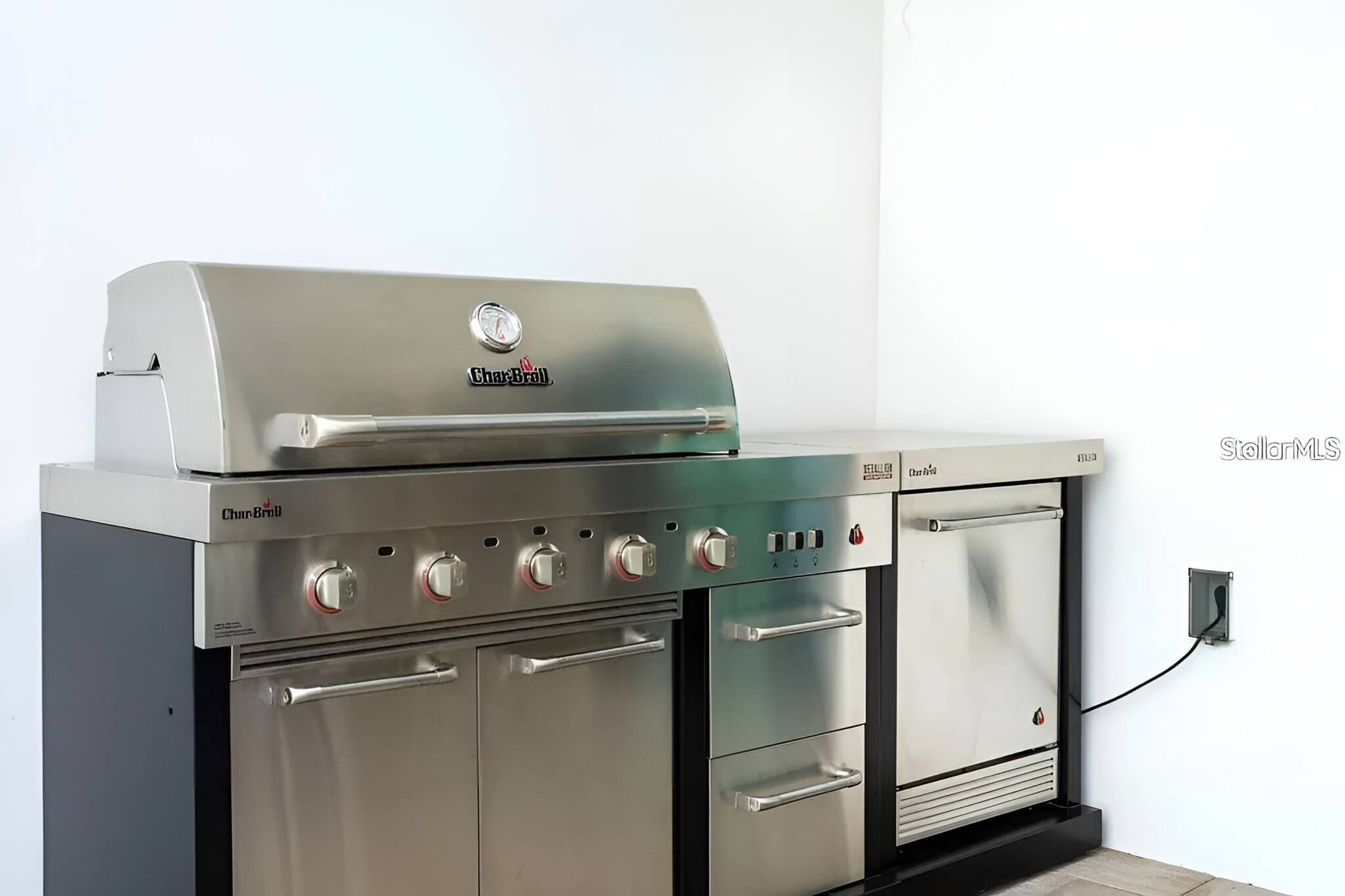 A Char-Broil gas grill with four burners, a side burner, and a built-in oven.