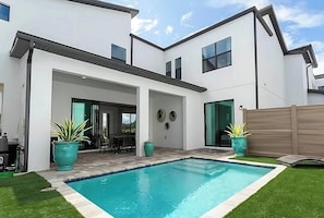 A modern two-story house with a swimming pool, a patio with outdoor furniture, and a wooden fence. - 5BR Family Home w Private Pool Near Disney (Davenport)