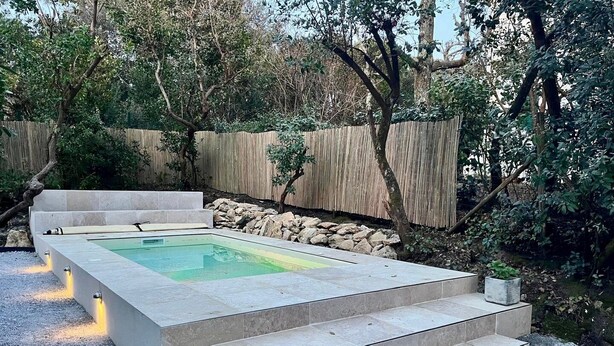 A rectangular pool with steps leading up to it, surrounded by a wooden fence and trees. - La Villa Pylataise – Pyla sur mer- Swimming pool (Pyla sur Mer)