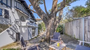 A modern house with a large tree, outdoor seating, and a patterned rug. - La Villa Pylataise – Pyla sur mer- Swimming pool (Pyla sur Mer)