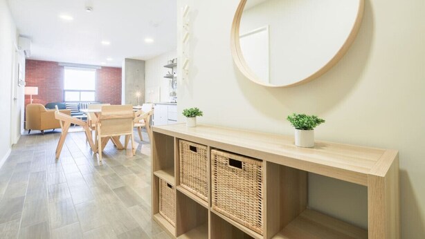 A modern room with a wooden console table, wicker baskets, a round mirror, and a small potted plant. - ¡A pasos de la Macroplaza! Alberca y Gimnasio (Monterrey)
