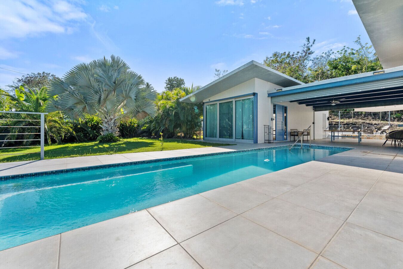 A modern house with a swimming pool, a covered patio, and a well-maintained garden.