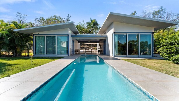 A modern house with a swimming pool, large glass windows, and a patio area. - Two bedroom  in Puerto Rico, Aguada (Aguada)