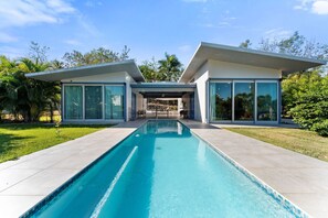 A modern house with a swimming pool, large glass windows, and a patio area. - Two bedroom  in Puerto Rico, Aguada (Aguada)