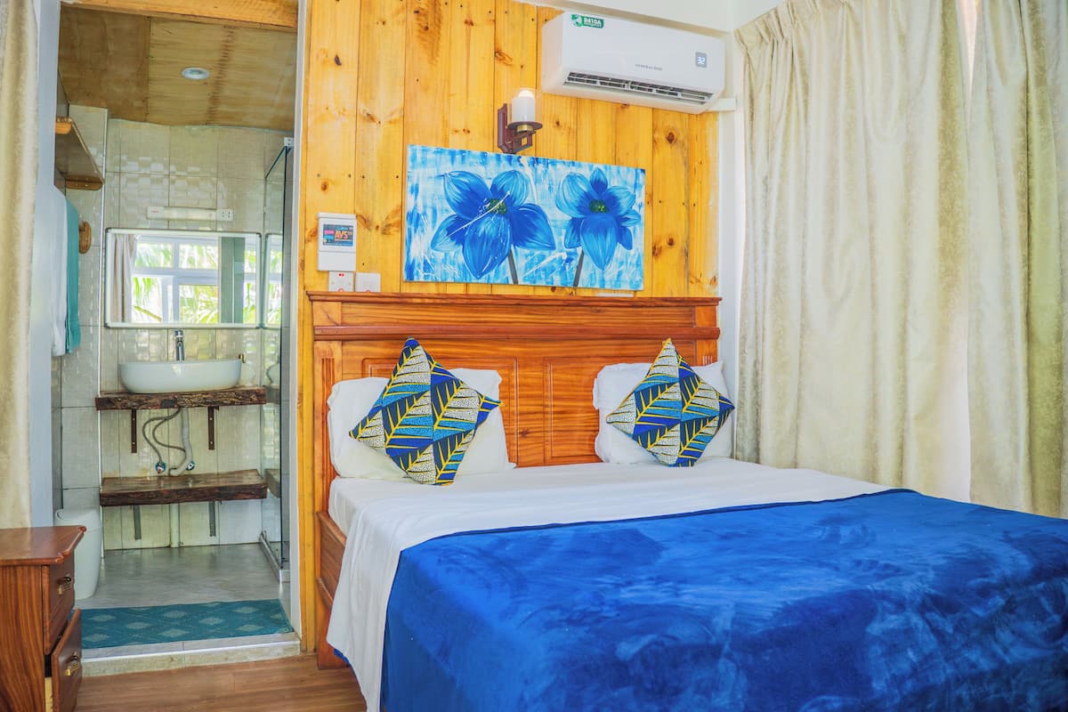 Una habitación de madera con una cama, un lavamanos y una ducha.