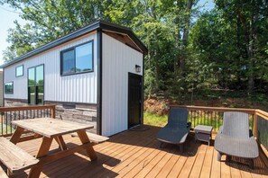 A modern cabin with a deck, a picnic table, and outdoor seating. - Busted Pallet (Anderson)