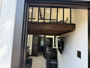 A room with a wooden ceiling, a bed, a desk, and a mirror. - Busted Pallet (Anderson)