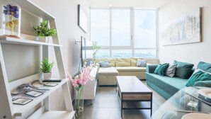 Una sala moderna con un sofá, una mesa de centro y estanterías con plantas.