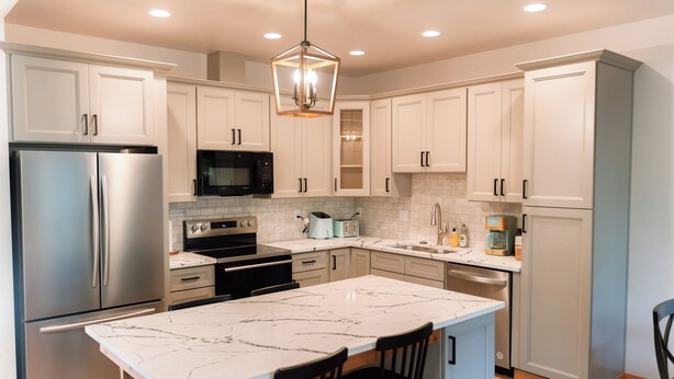 A modern kitchen with white cabinets, stainless steel appliances, a marble island, and a pendant light. - The Kat's meow, 3-bedroom duplex in Nehalem (Nehalem)