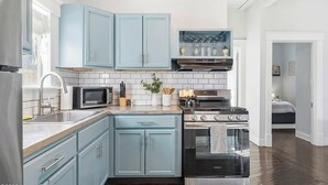 A kitchen with light blue cabinets, a microwave, a stove, and a sink. - Entire & Private Carriage House Near Downtown + 2 Complementary Housekeeping. (Louisville)