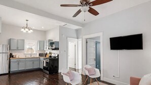 A modern kitchen with grey cabinets, a black stove, and a ceiling fan. - Entire & Private Carriage House Near Downtown + 2 Complementary Housekeeping. (Louisville)