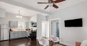 A modern kitchen with grey cabinets, a black stove, and a ceiling fan. - Entire & Private Carriage House Near Downtown + 2 Complementary Housekeeping. (Louisville)