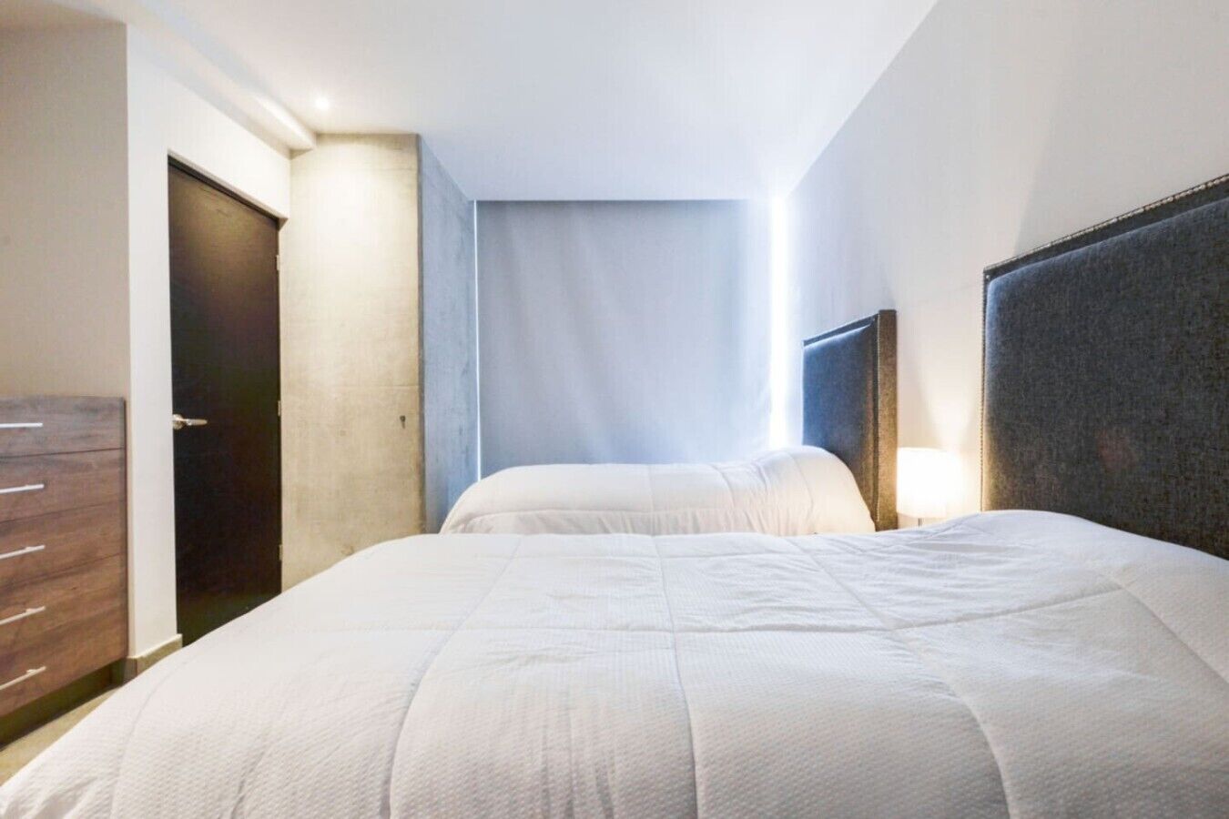 Ein Hotelzimmer mit einem Bett, einem Schminktisch und einer Tür.