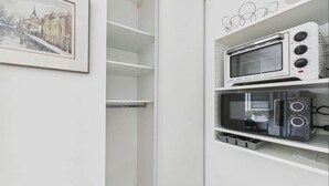 Una cucina con forno a microonde, tostapane e un quadro incorniciato con vista sulla città.