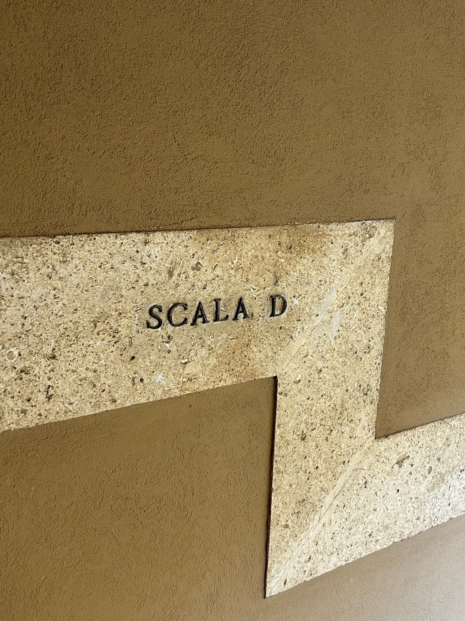 Paredes texturizadas com a inscrição 'SCALA D'.