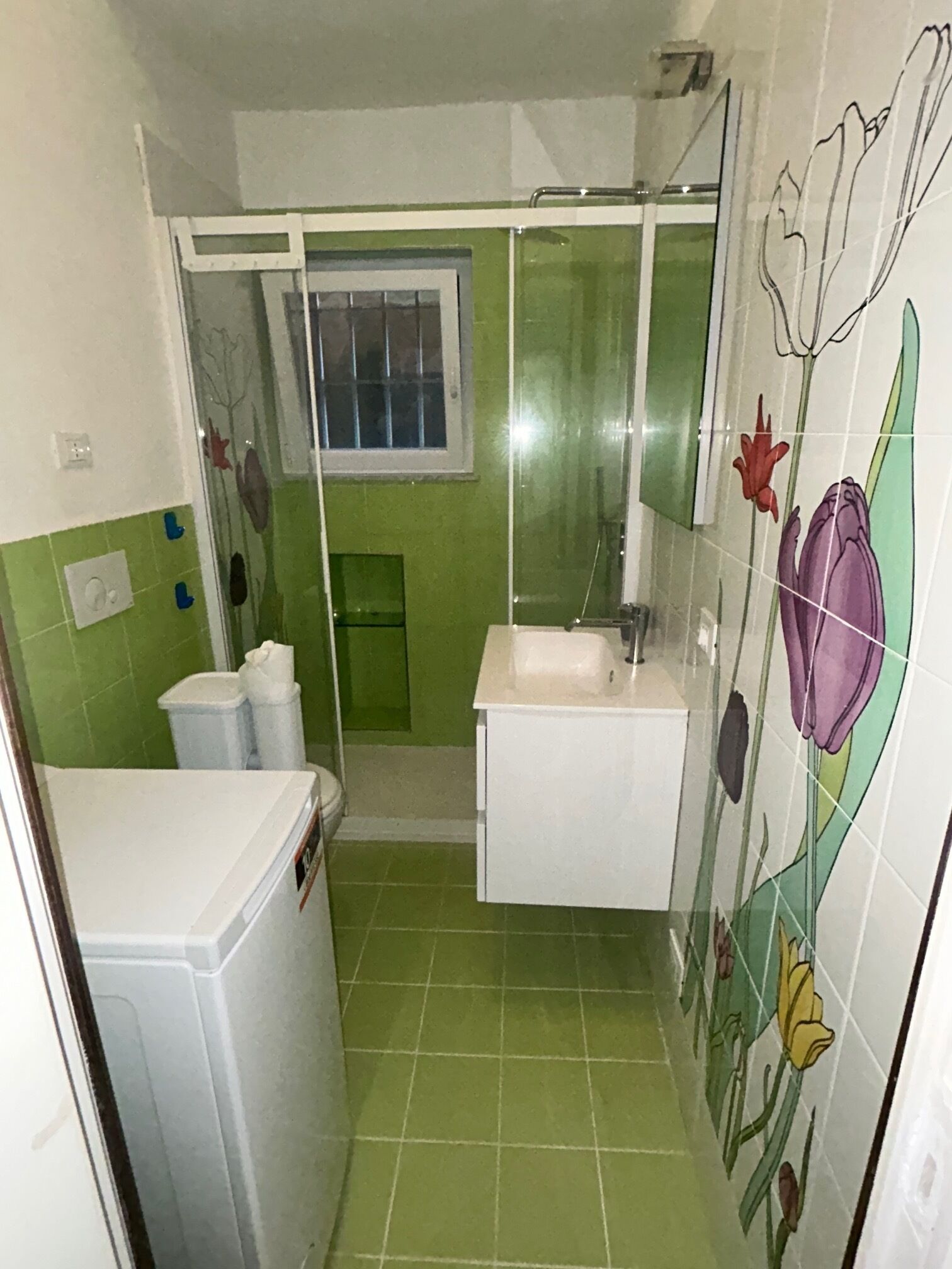 A small bathroom with a shower, a sink, and a toilet.