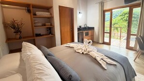 Un dormitorio con cama, armario, baño y balcón con vistas.