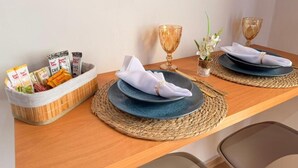 Una mesa de comedor con dos platos, una servilleta, una cesta de aperitivos y dos vasos de vidrio.