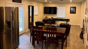 A kitchen with a refrigerator, dining table, chairs, and a flat-screen TV. - Children and Pet Friendly/ EV Charger/Wi-Fi/Fenced (Richland Hills)
