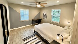 A bedroom with a bed, a ceiling fan, a desk, and two windows with blinds. - Children and Pet Friendly/ EV Charger/Wi-Fi/Fenced (Richland Hills)