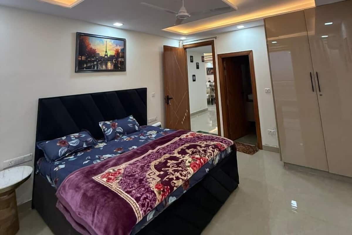 Un dormitorio con cama, ventilador de techo, puerta y armario.