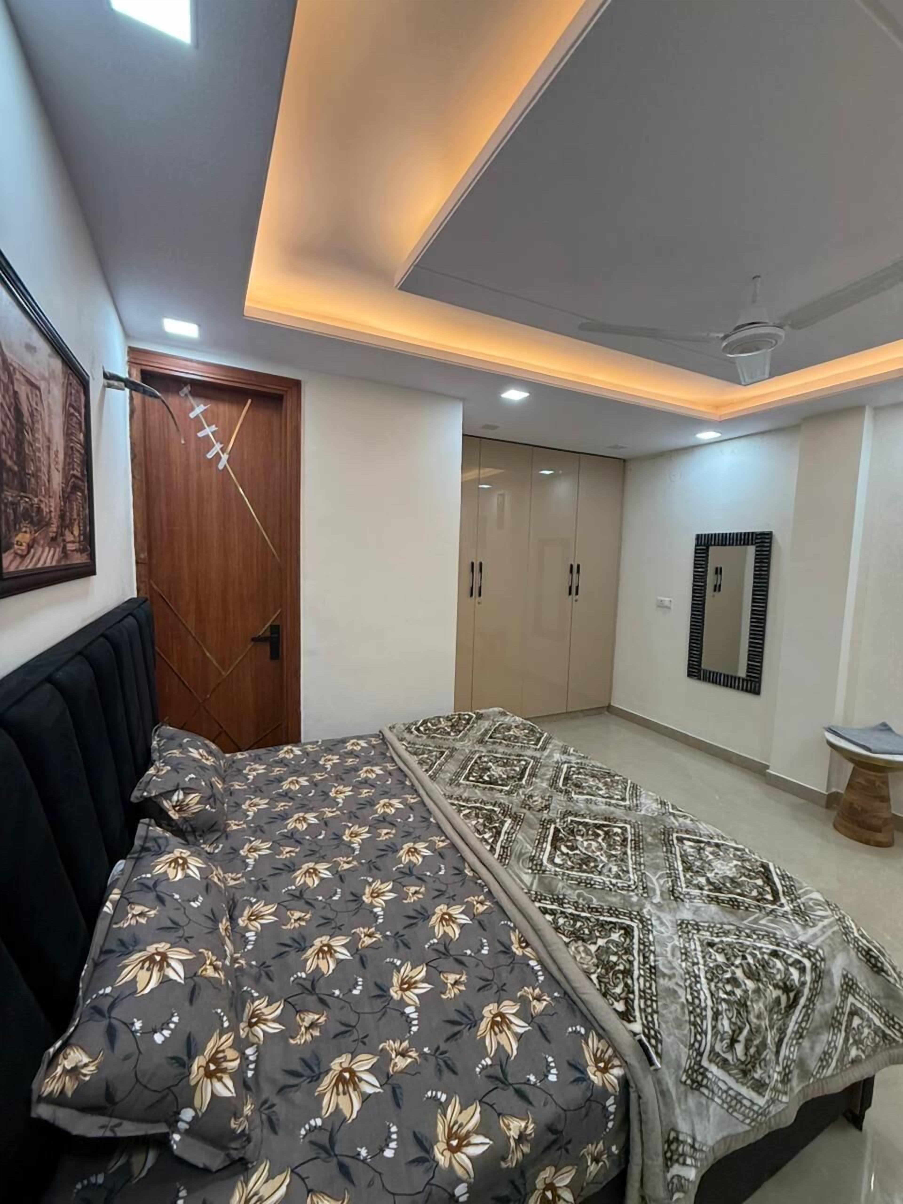 Un dormitorio con cama, armario y espejo.