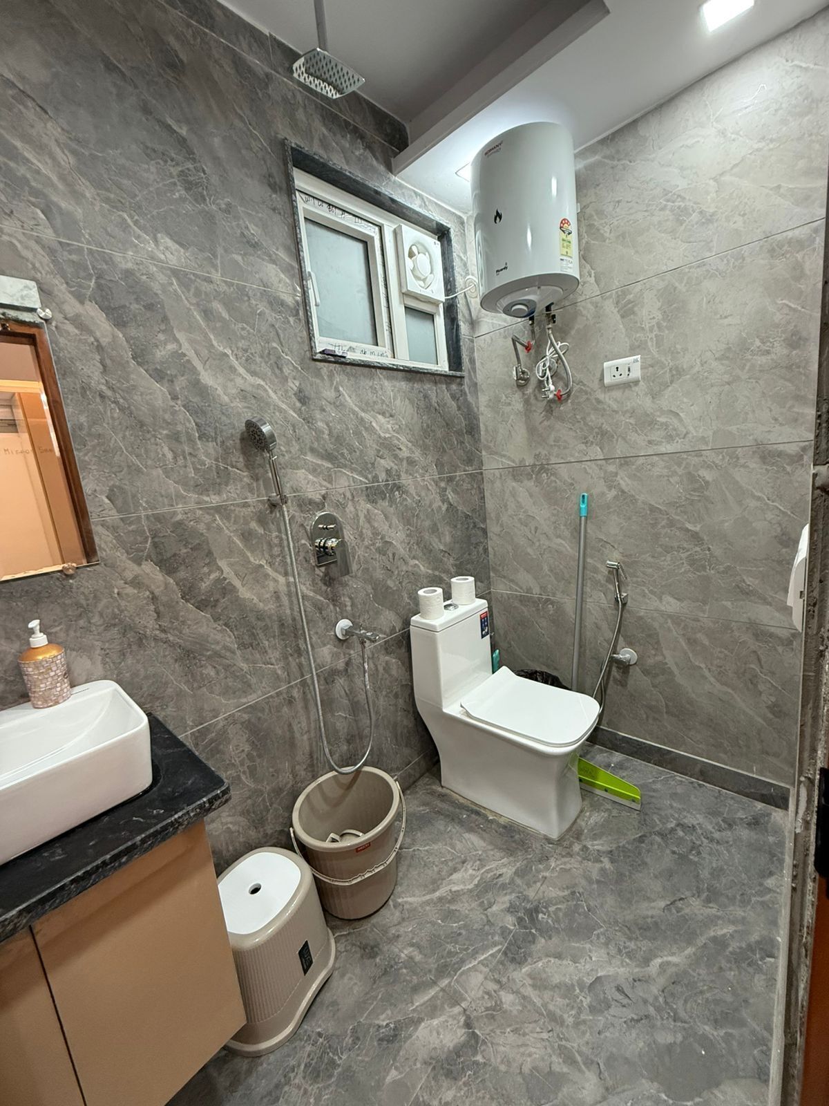A bathroom with a toilet, bidet, and shower.