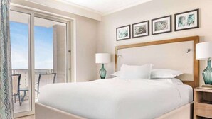 Ein Hotelzimmer mit einem großen Bett, einem Balkon mit Blick und Holzboden.