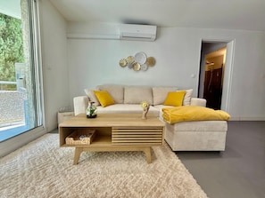 Ein modernes Wohnzimmer mit einer Couch, einem Couchtisch und einem kleinen Beistelltisch.