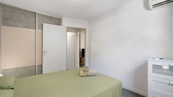 Una camera da letto con un letto, un armadio, una cassettiera e uno specchio.