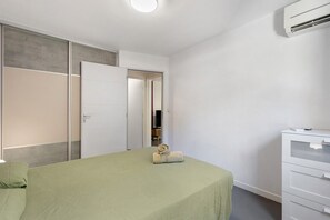 A bedroom with a bed, a wardrobe, a dresser, and a mirror. - Between Sea and Lagoon – 2-Room Apartment in Sète (Sète)