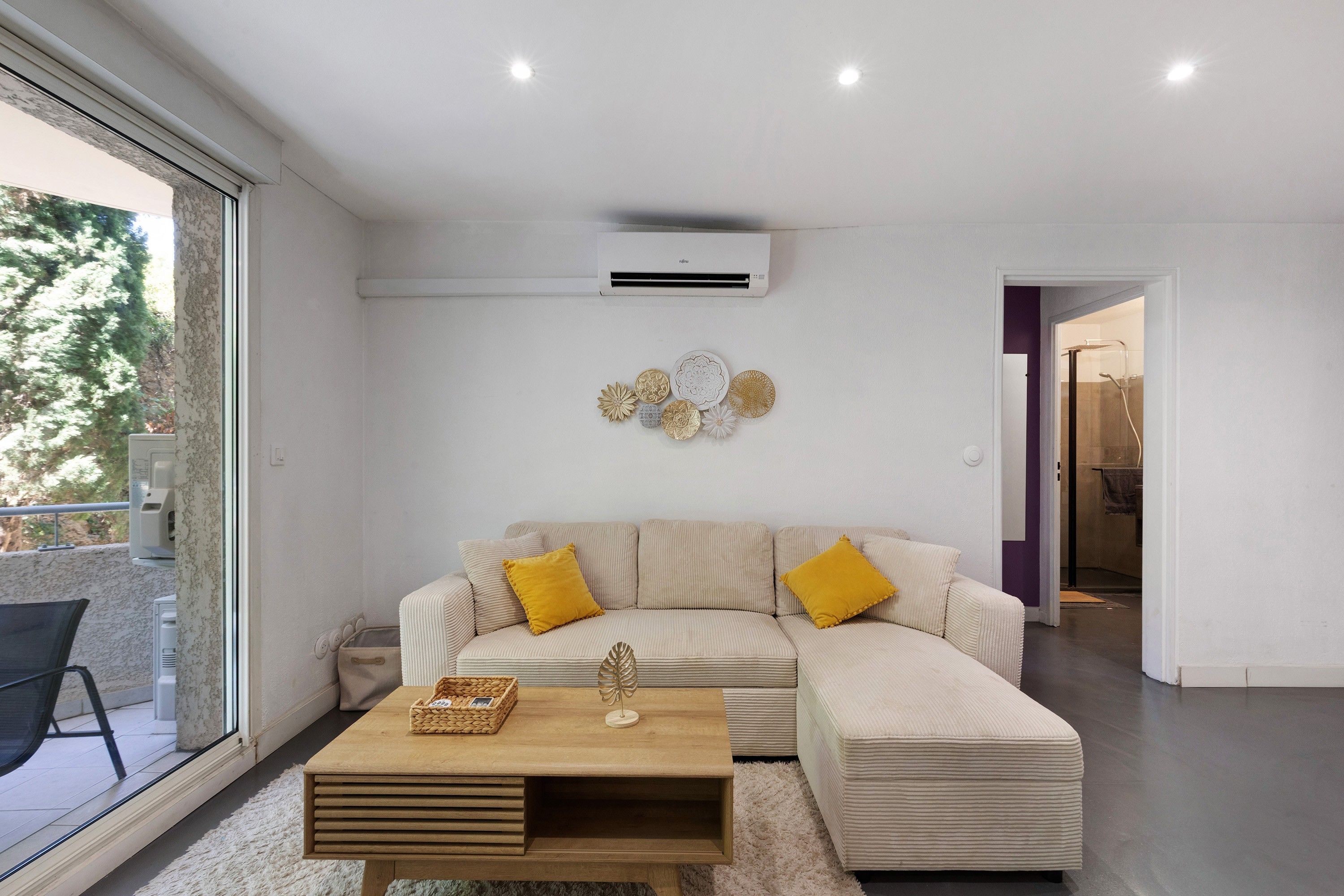 A modern living room with a sofa, a wooden coffee table, and decorative wall art.
