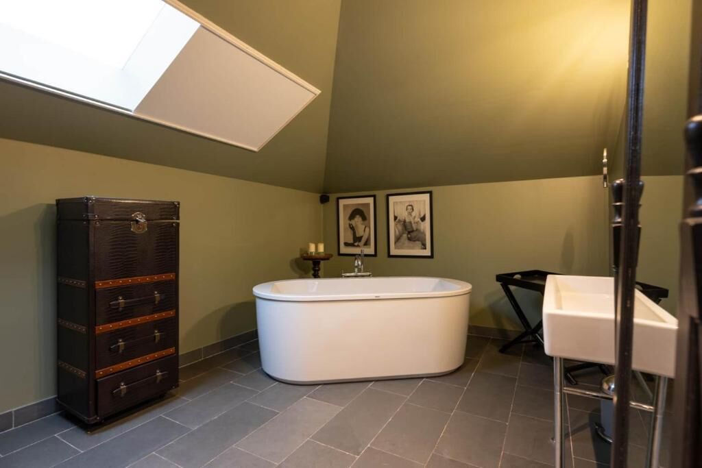 Ein Badezimmer mit freistehender Badewanne, einem Waschtisch und einem Schrank mit Schubladen.