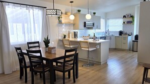 A modern kitchen with white cabinets, a central island, and pendant lighting.