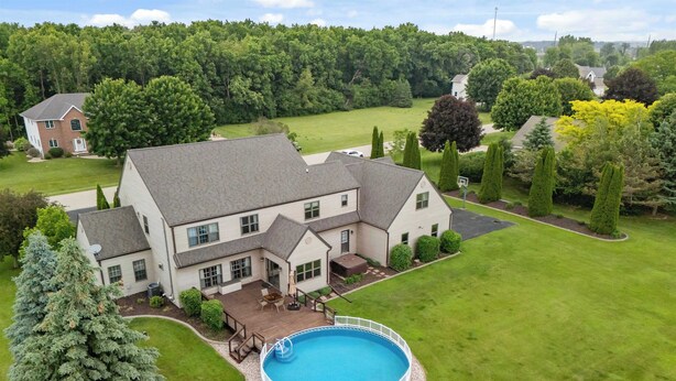 A large house with a swimming pool, surrounded by a well-maintained lawn and trees. - Gorgeous 4-bedroom house with AC in charming Winneconne (Winneconne)
