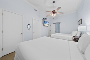 A hotel room with two beds, a ceiling fan, a television, and a window with curtains. - Phoenix East 009 - Ground-floor Gulf-front Condo - Sleeps 8 - Orange Beach, AL (Orange Beach)