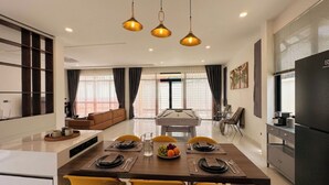 A modern living space with a dining area, kitchen, and seating area. - Private pool VIlla in Pattaya central near walking street 7BR luxury pool table (Muang Pattaya)