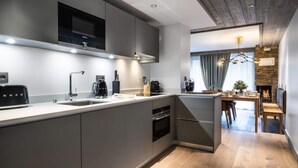 A modern kitchen with a built-in oven, a microwave, and a coffee maker. - Wifi, 200m from ski slopes, 2nd floor, fitness, swimming pool, sauna, hammam, balcony, tv (Les Gets)