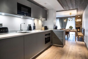 A modern kitchen with a built-in oven, a microwave, and a coffee maker. - Wifi, 100m from resort center, 2nd floor, fitness, swimming pool, sauna, hammam, balcony, tv (Les Gets)