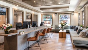 A modern reception area with a counter, multiple computer monitors, and seating arrangements. - Wifi, 200m from ski slopes, 2nd floor, fitness, swimming pool, sauna, hammam, balcony, tv (Les Gets)