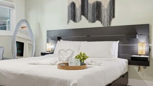 A modern hotel room with a large bed, a wall-mounted artwork, and a bedside table with a lamp. - The Summit 131 - Ground Floor Beachfront! Walk to Sand! (Panama City Beach)