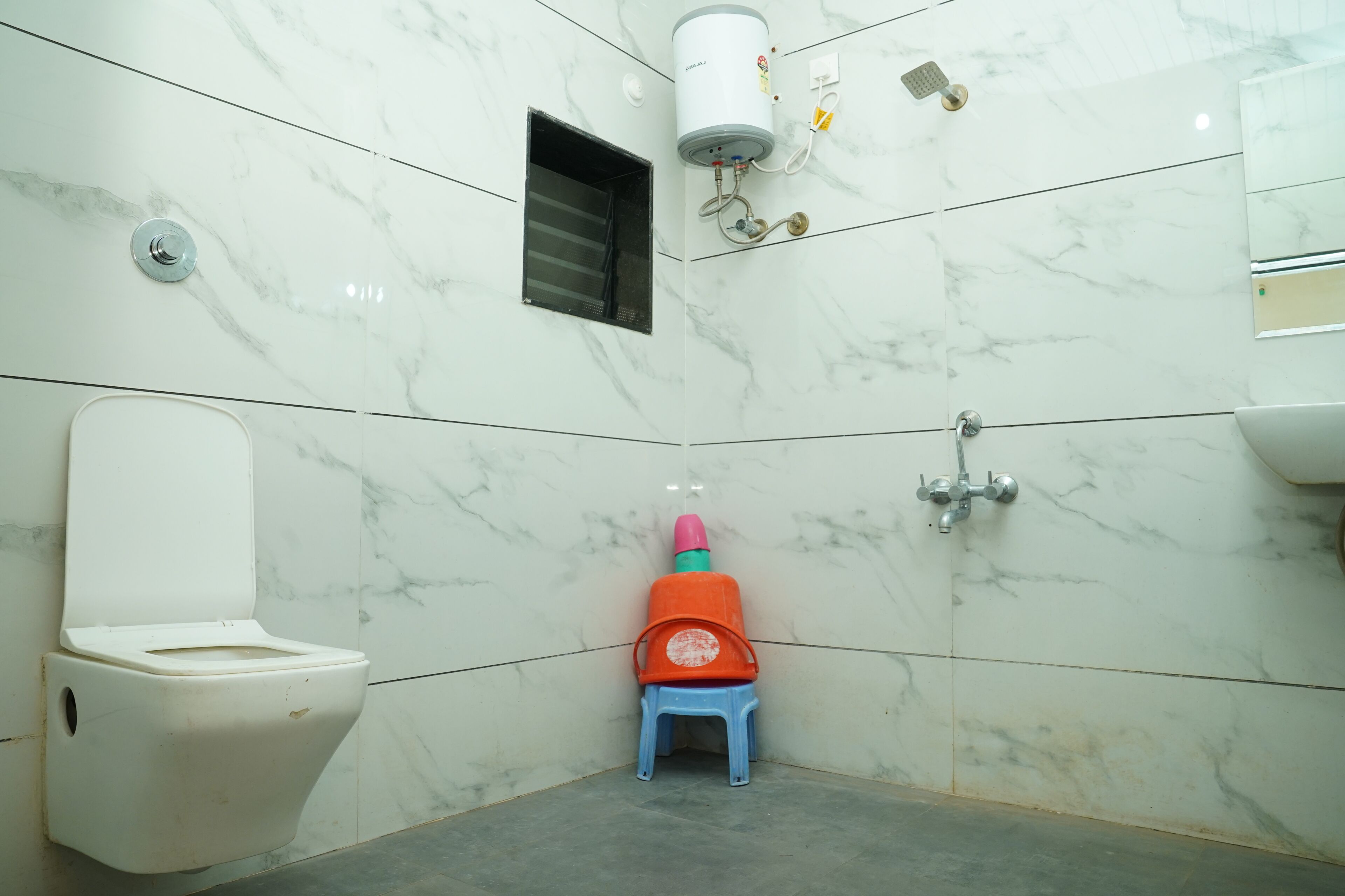 A bathroom with a toilet, a shower, and a sink.
