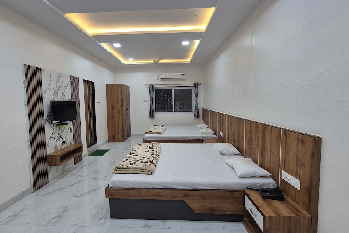 A modern bedroom with two beds, a TV, and an air conditioning unit.