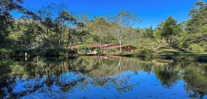 A house by a calm lake surrounded by trees. - Casa aconchegante em Petrópolis com vista Montanha (Petrópolis)