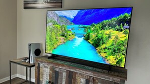 Ein Fernseher auf einer Holzkommode, auf dem eine schöne Landschaft zu sehen ist.