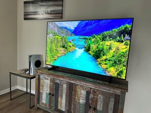 Ein Fernseher auf einer Holzkommode, auf dem eine schöne Landschaft zu sehen ist.